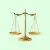 A gold balance scale on a light green background, symbolizing justice, fairness, or equality.